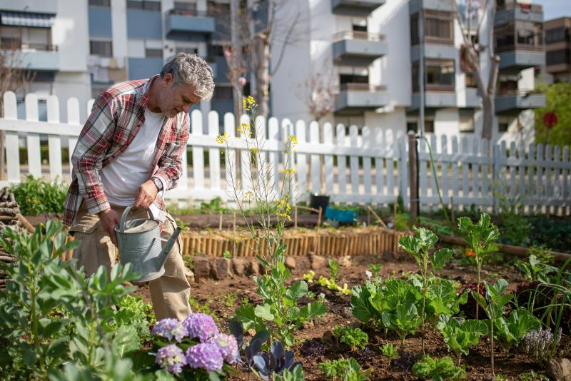 Homme qui arrose son jardin