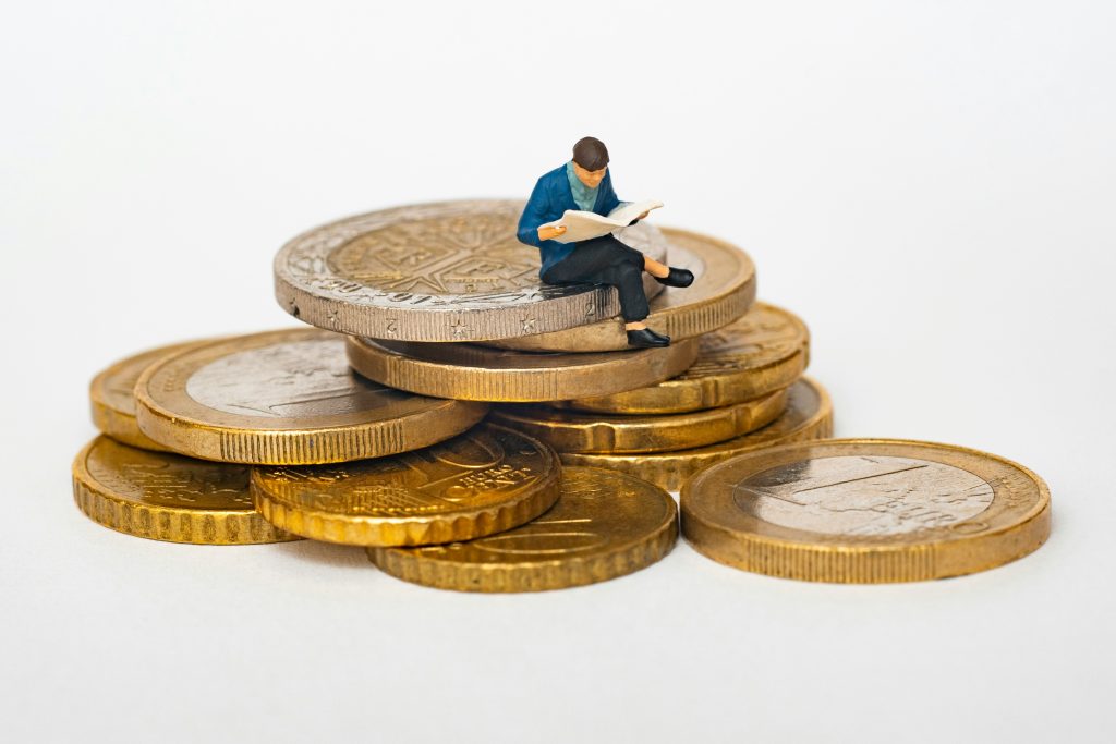 Un homme assis sur des pièces en euro.