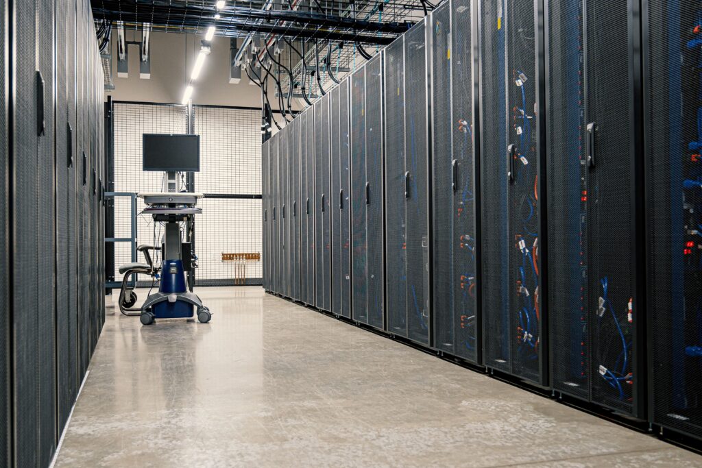 Une photo d'un computer de contrôle au milieu des des rangées d'appareils de stockage de données